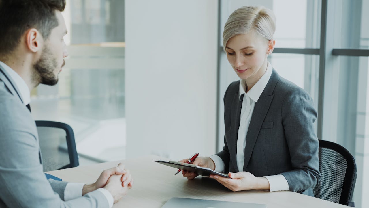 Two professionals in a modern office discussing business. Bright, professional setting.